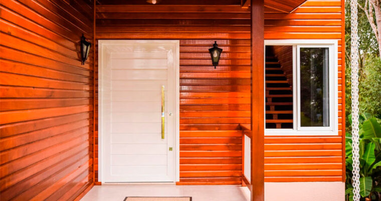Imagem de uma casa de madeira com uma porta principal e um lindo puxador de madeira